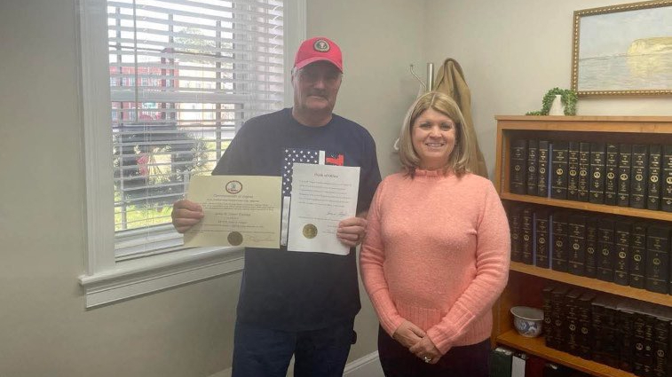 Two people standing in front of a bookcase