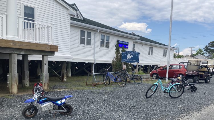 School building with bicycles and mini-ATVs in front of it.