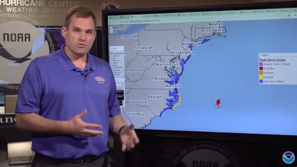Man stands in front of a screen showing the US East Coast.