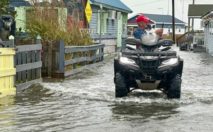 Tommy Eskridge takes photos while riding an ATV.